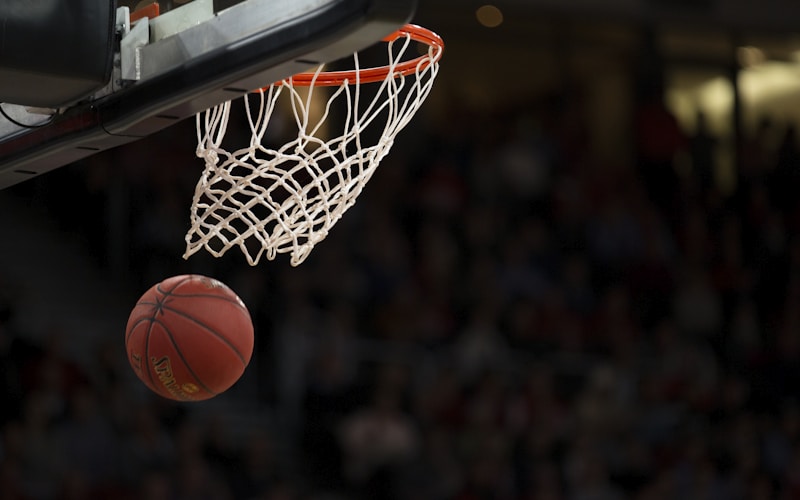 NBA篮球比赛现场，球员奋力扣篮，记分牌显示激烈比分
